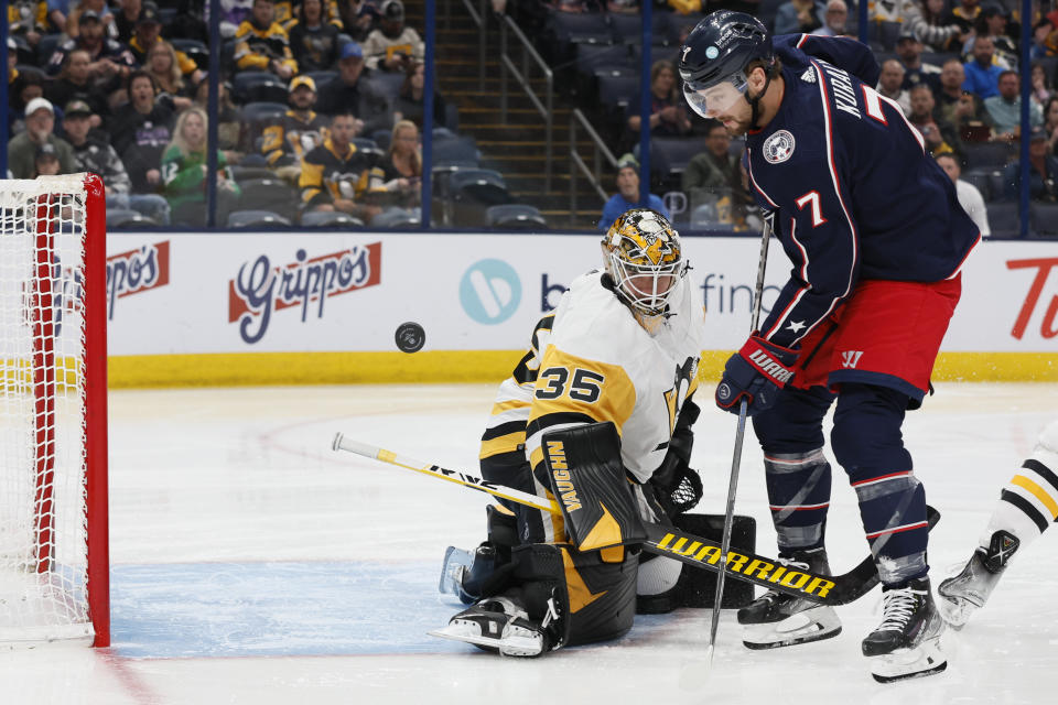 Pittsburgh Penguins' Tristan Jarry, left, makes a save against Columbus Blue Jackets' Sean Kuraly during the second period of an NHL hockey game Thursday, April 13, 2023, in Columbus, Ohio. (AP Photo/Jay LaPrete)