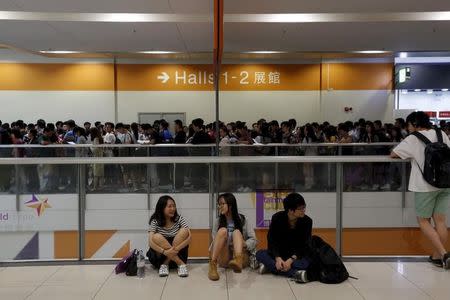 Students chat as others line up to take part in SAT examinations at Asia-World Expo near Hong Kong Airport in Hong Kong, China October 3, 2015. REUTERS/Bobby Yip