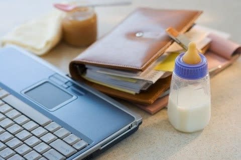 Laptop, planner and baby bottle on table - Credit: Tetra images RF/Tetra Images