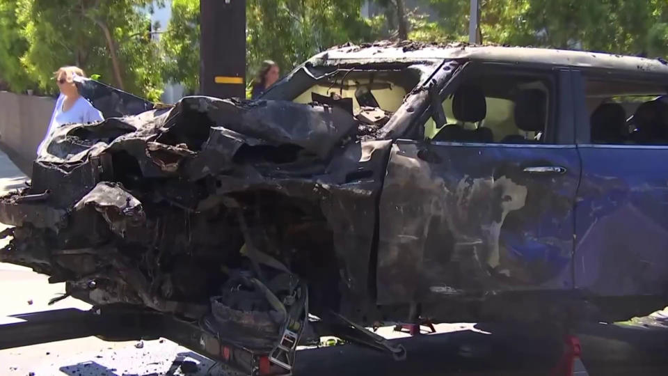 A blue Mini Cooper with severe collision and burn damage. (TODAY)