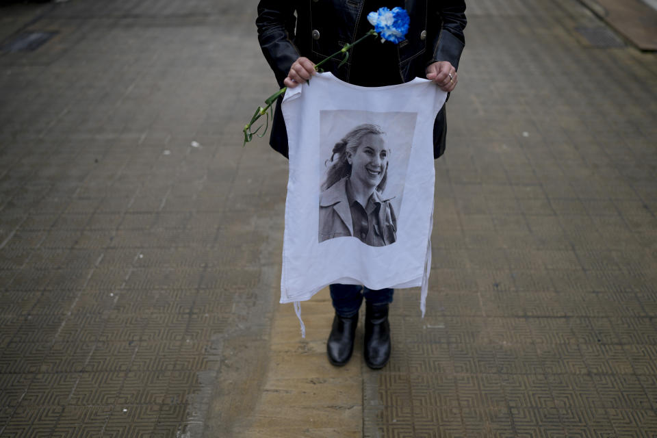 A woman holds a T-shirt featuring Argentina's late first lady Maria Eva Duarte de Peron, better known as Evita, as she waits her turn to approach Evita's tomb in Buenos Aires, Argentina, Tuesday, July 26, 2022. Argentines commemorate the 70th anniversary of the death of their most famous first lady, who died of cancer on July 26, 1952 at the age of 33. (AP Photo/Natacha Pisarenko)