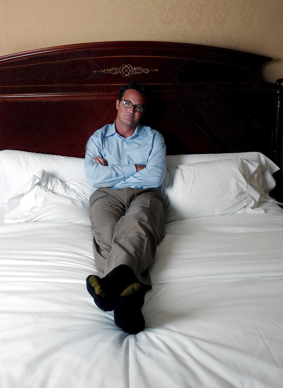 FILE - Actor Matthew Perry poses in his hotel bedroom in New York, Aug. 7, 2002. Perry, who starred as Chandler Bing in the hit series “Friends,” has died. He was 54. The Emmy-nominated actor was found dead of an apparent drowning at his Los Angeles home on Saturday, according to the Los Angeles Times and celebrity website TMZ, which was the first to report the news. Both outlets cited unnamed sources confirming Perry’s death. His publicists and other representatives did not immediately return messages seeking comment. (AP photo/Gino Domenico, File)