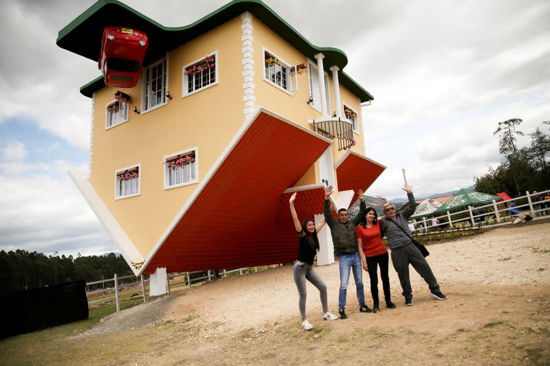 Personas posan para una foto afuera de la casa al revés, en Guatavita