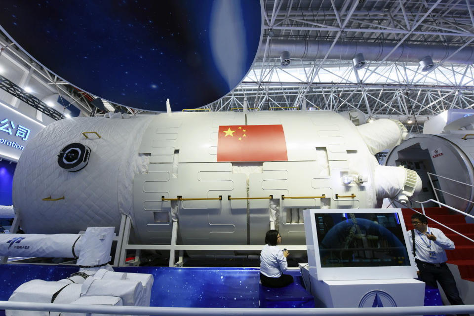 In this Nov. 7, 2018 photo, visitors look at a life-size model of the Tianhe core module of China's next space station at the Airshow China in Zhuhai in southern China's Guangdong Province. China on Thursday, June 17, 2021 has launched its first crewed space mission in five years, sending three astronauts to a new space station that marks a milestone in the country's ambitious space program. (Chinatopix via AP)