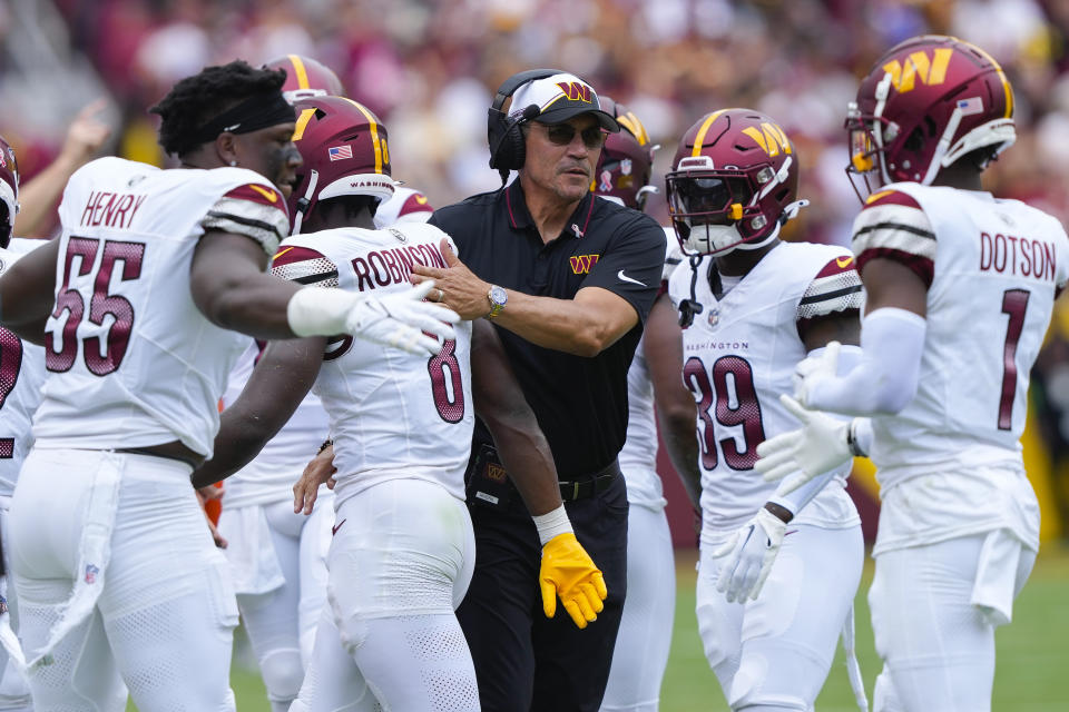 Washington Commanders head coach Ron Rivera, center, congratulates running back Brian Robinson Jr. (8) after scoring a touchdown against the Arizona Cardinals during the first half of an NFL football game, Sunday, Sept. 10, 2023, in Landover, Md. (AP Photo/Susan Walsh)