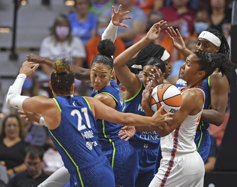 Connecticut Sun forward Alyssa Thomas, front right, battles against, from left to right, Minnesota Lynx guard Kayla McBride (21), forward Aerial Powers (3), forward Napheesa Collier (24), and center Sylvia Fowles (34) for a rebound during a WNBA basketball game Sunday, Aug. 14, 2022, in Uncasville, Conn. (Sean D. Elliot/The Day via AP)