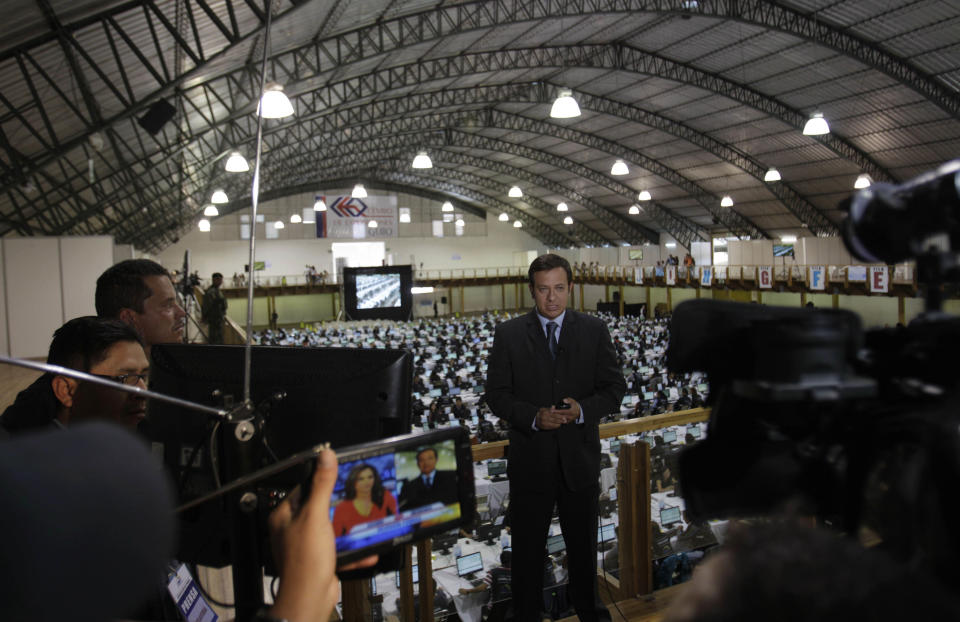 In this Aug. 31, 2012 photo, Alex Cevallos, a journalist from the private television channel Ecuavisa, reports from the National Election Council as the council revises the registration of political parties in Quito, Ecuador. To Ecuador's President Rafael Correa, Australian-born Wikileaks founder Julian Assange is a truth-teller who deserves praise and protection as he knocks down the walls of government secrets. But when it comes to Ecuador's opposition media, Correa says too many journalists serve special interests and have immense, unchecked power. (AP Photo/Dolores Ochoa)