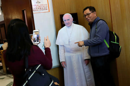 A Catholic poses for a photo with a cardboard cutout of Pope Francis at a church in Taipei, Taiwan March 11, 2018. REUTERS/Tyrone Siu