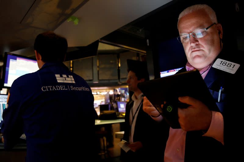 FILE PHOTO: Traders work on the floor of the NYSE in New York