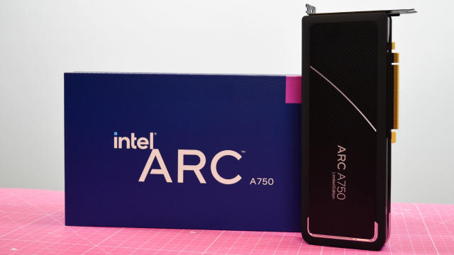  An Intel Arc A750 graphics card on a pink desk mat next to its retain packaging 