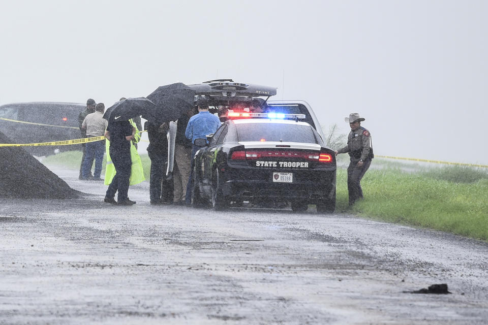 Law enforcement officers gather near the scene where the body of a woman was found near Interstate 35 north of Laredo, Texas on Saturday, Sept. 15, 2018. A U.S. Border Patrol agent suspected of killing four women was arrested early Saturday after a fifth woman who had been abducted managed to escape from him and notify authorities, law enforcement officials said, describing the agent as a "serial killer." (Danny Zaragoza/The Laredo Morning Times via AP)