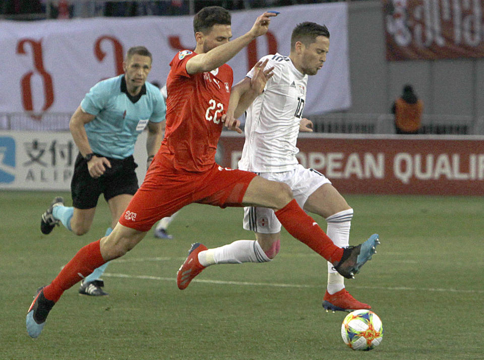 Switzerland's Fabian Schar, left, and Georgia's Jano Ananidze challenge for the ball during the Euro 2020 group D qualifying soccer match between Georgia and Switzerland at Boris Paichadze Erovnuli stadium in Tbilisi, Georgia, Saturday, March 23, 2019. (AP Photo/Shakh Aivazov)