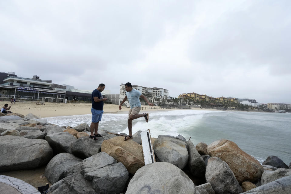 Tourists walk near a beach in Cabo San Lucas, Mexico, Saturday, Oct. 21, 2023. Hurricane Norma made landfall near the resorts of Los Cabos at the southern tip of Mexico’s Baja California Peninsula on Saturday afternoon, then later weakened to a tropical storm over land. (AP Photo/Fernando Llano)