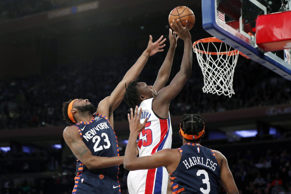New York Knicks center Mitchell Robinson (23) defends Detroit Pistons forward Sekou Doumbouya (45) during the first half of an NBA basketball game in New York, Sunday, March 8, 2020. Knicks forward Maurice Harkless (3) watches, lower right. (AP Photo/Kathy Willens)