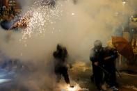 Anti-extradition bill demonstrators react as riot police fire tear gas after a march to call for democratic reforms in Hong Kong