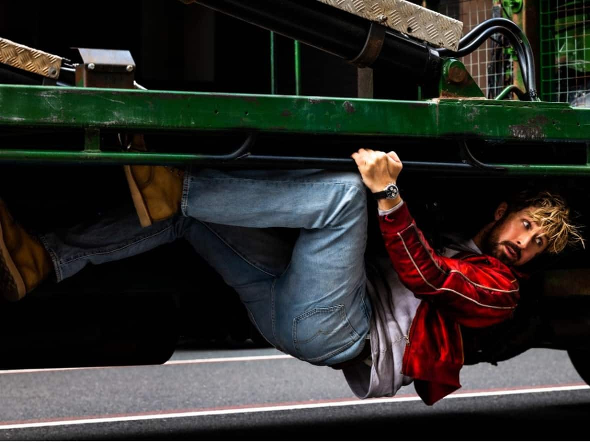 Stuntman Colt Seavers hangs on in a scene from The Fall Guy, starring Ryan Gosling.  (Universal Pictures - image credit)