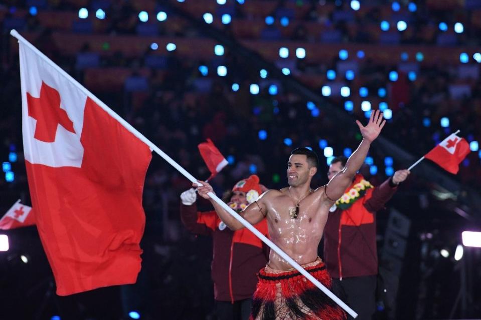 El portador de la bandera Pita Taufatofua, de Tonga, sorprendió a los espectadores al aparecer sin camisa en la ceremonia. (AFP)
