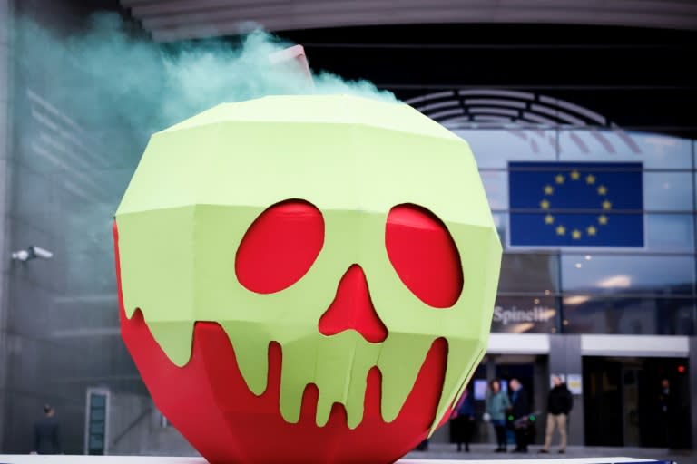 Une installation représentant "une pomme empoisonnée" lors d'une manifestation devant le Parlement européen, le 11 avril 2024 à Bruxelles (Kenzo TRIBOUILLARD)