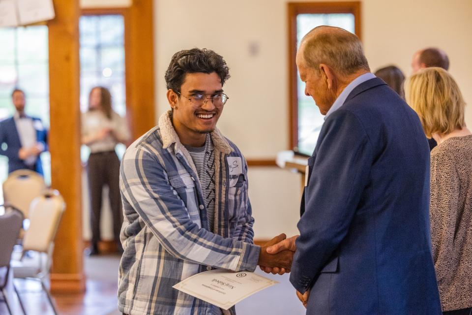 Niraj Subedi, a graduate of the University of Utah, shakes Roger Boyer’s hand during the One Refugee graduation celebration at the Garden Place at Heritage Park in Salt Lake City on May 8, 2023. | Ryan Sun, Deseret News