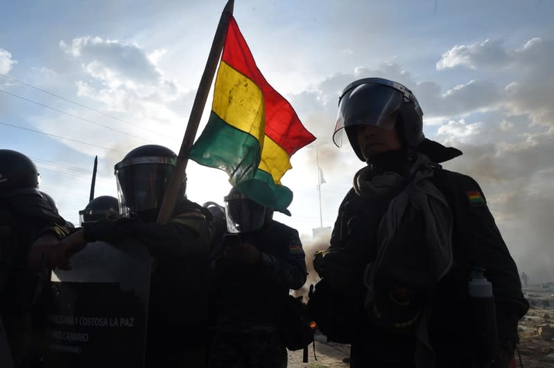 Silhouettes of riot police officers are seen in Sacaba