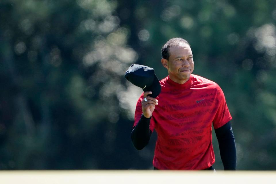 Tiger Woods tips his hat to the fans as they applaud as he walks up No. 18 during the final round of the Masters at Augusta National Golf Club.