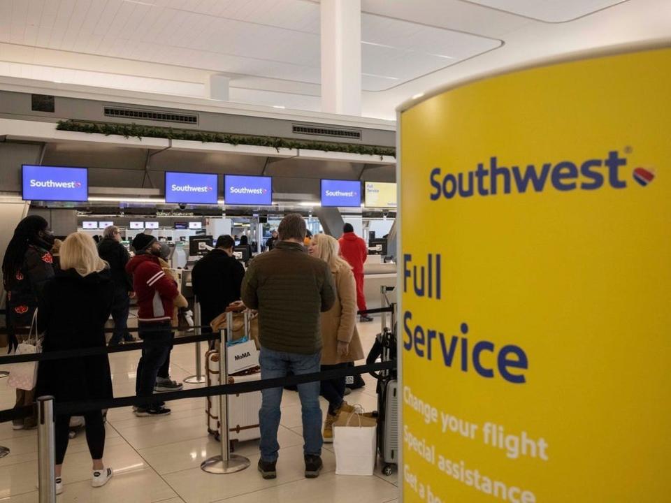 Passengers wait in line to check in for their flights at Southwest Airlines service desk at LaGuardia Airport, Tuesday, Dec. 27, 2022, in New York.