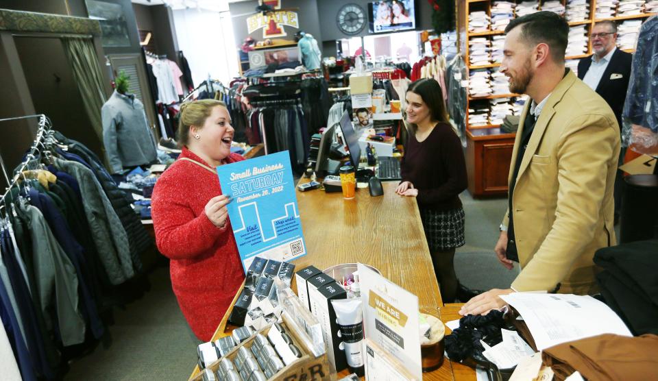 Sarah Dvorsky, executive director of Ames Main Street, talks to Nick Hilmer and Grace Koehler, employees of Moorman Clothiers, about Small Business Saturday in downtown Ames.