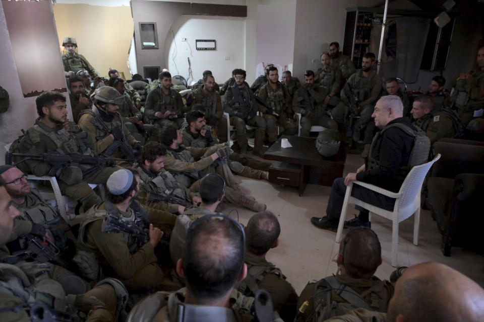 Israel's Prime Minister Benjamin Netanyahu, right, speaks to soldiers as he visits the northern Gaza Strip, where he received security briefings with commanders and soldiers, on Monday, Dec. 25, 2023. (Avi Ohayon/GPO/Handout via AP)