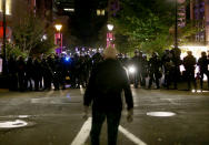 Portland Police and protesters clashed in a demonstration in downtown Portland, early Thursday, Aug. 13, 2020. Officers used tear gas to break up the crowd of several hundred people who gathered near the Mark O. Hatfield U.S. Courthouse, the neighboring Multnomah County Justice Center and a nearby police precinct station. (Sean Meagher/The Oregonian via AP)