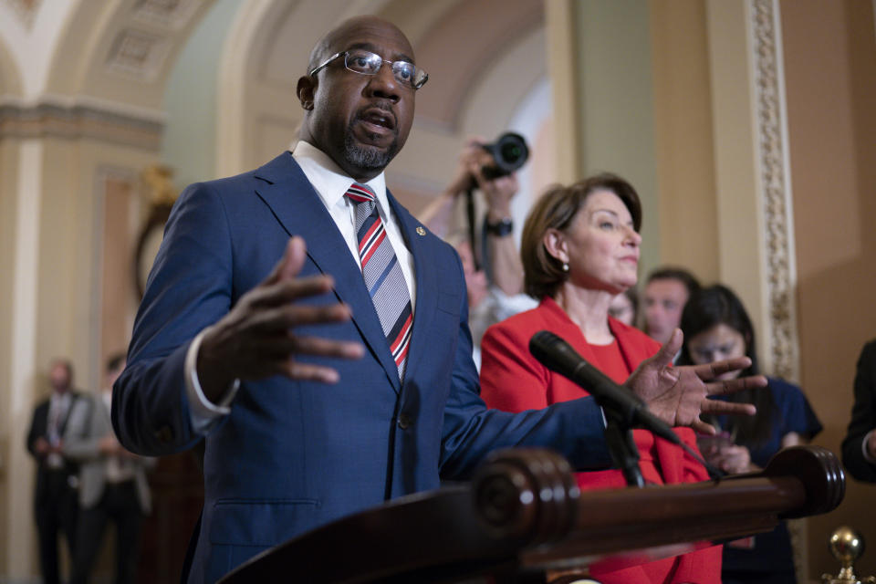 FILE - In this June 22, 2021, file photo Sen. Raphael Warnock, D-Ga., joined at right by Sen. Amy Klobuchar, D-Minn., speaks with reporters before a key test vote on the For the People Act, a sweeping bill that would overhaul the election system and voting rights, at the Capitol in Washington. (AP Photo/J. Scott Applewhite, File)