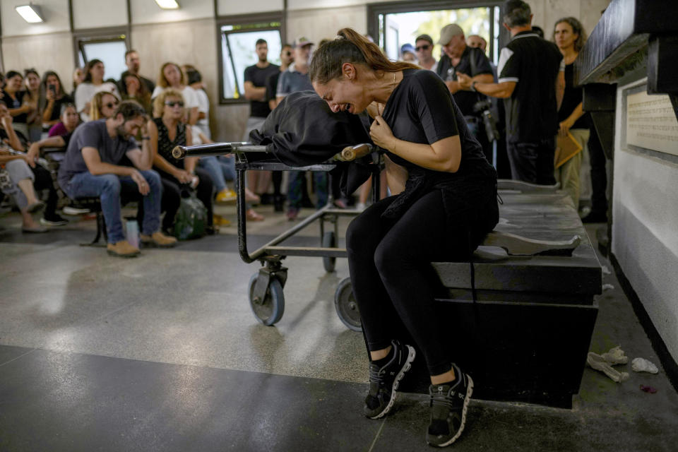 Mourners react beside the body of Mapal Adam, during her funeral in Tel Aviv, Israel, Wednesday, Oct. 11, 2023. Adam was killed by Hamas militants on Saturday as they carried out an unprecedented, multi-front attack that killed over 1,000 Israelis. (AP Photo/Francisco Seco)