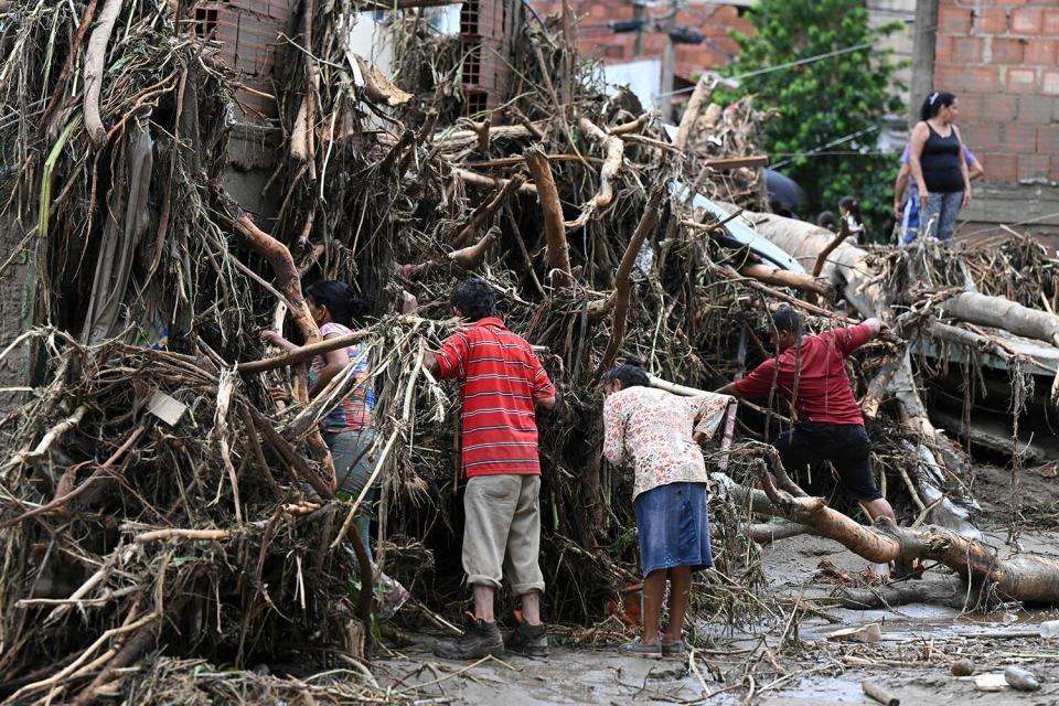 Residents search for their missing relatives in the rubble of a house destroyed by a landslide during heavy rains in Las Tejerias, Aragua state, Venezuela, on October 9, 2022