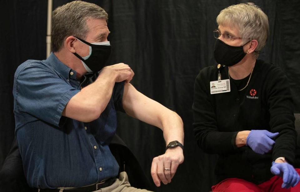 North Carolina Governor Roy Cooper rolls up his sleeve for Carolyn Knaup, RN, as he prepares to receive his COVID-19 vaccination at WakeMed on Wednesday, March 3, 2021 at WakeMed in Raleigh, N.C.