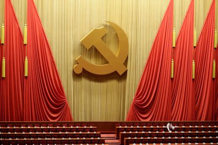 A staff member prepares reports for delegates inside the Great Hall of the People before the opening of the 19th National Congress of the Communist Party of China in Beijing, China October 18, 2017. REUTERS/Jason Lee