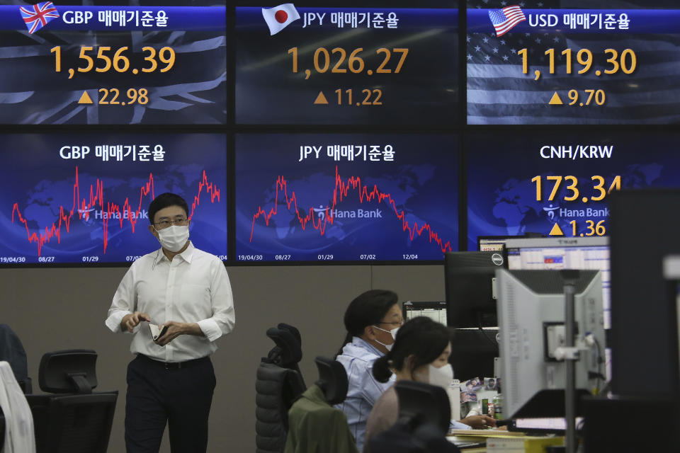 A currency trader passes by screens showing foreign exchange rates at the foreign exchange dealing room of the KEB Hana Bank headquarters in Seoul, South Korea, Tuesday, May 4, 2021. Asian shares were mixed Tuesday after strong corporate earnings and economic data lifted stocks on Wall Street. (AP Photo/Ahn Young-joon)