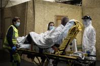 Ambulance crew work as a patient arrives at the CHR CItadelle hospital in Liege, Belgium, Thursday, Oct. 29, 2020. Belgium has announced restrictive measures across the country in an effort to curb the fast-rising tide of COVID-19, coronavirus cases. (AP Photo/Valentin Bianchi)