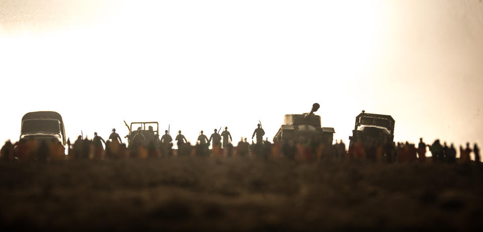 Captured by enemy concept. Military silhouettes and crowd on war fog sky background. World War Soldiers and armored vehicles movement while scared people watching. Artwork decoration. Selective focus