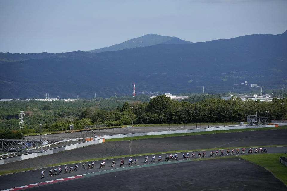 Cyclists compete during the men's cycling road race at the 2020 Summer Olympics, Saturday, July 24, 2021, in Oyama, Japan. (AP Photo/Christophe Ena)