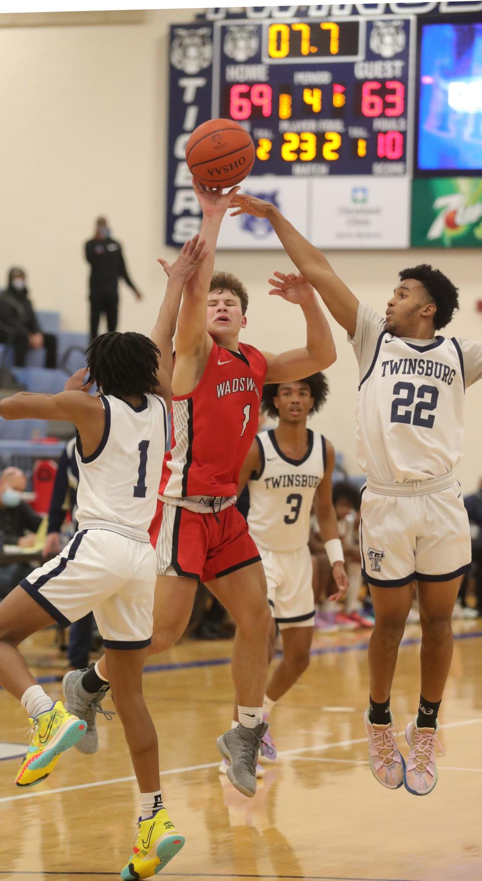 Wadsworth's Maxx Bosley sinks a 3-pointer with seven seconds remaining in the game as Twinsburg's Jayden Patton, left, and Adam Williams defend, Friday, Jan. 14, 2022 in Twinsburg.