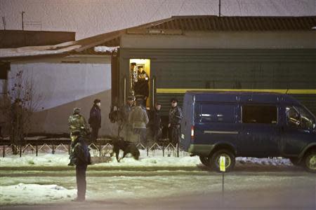 People get inside a carriage, which is believed to transport 30 people who were arrested over a Greenpeace protest at the Prirazlomnaya oil rig, in Murmansk before the train departure to St. Petersburg, November 11, 2013. REUTERS/Dmitri Sharomov/Greenpeace/Handout via Reuters