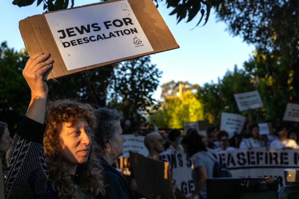 Demonstrators hold signs.