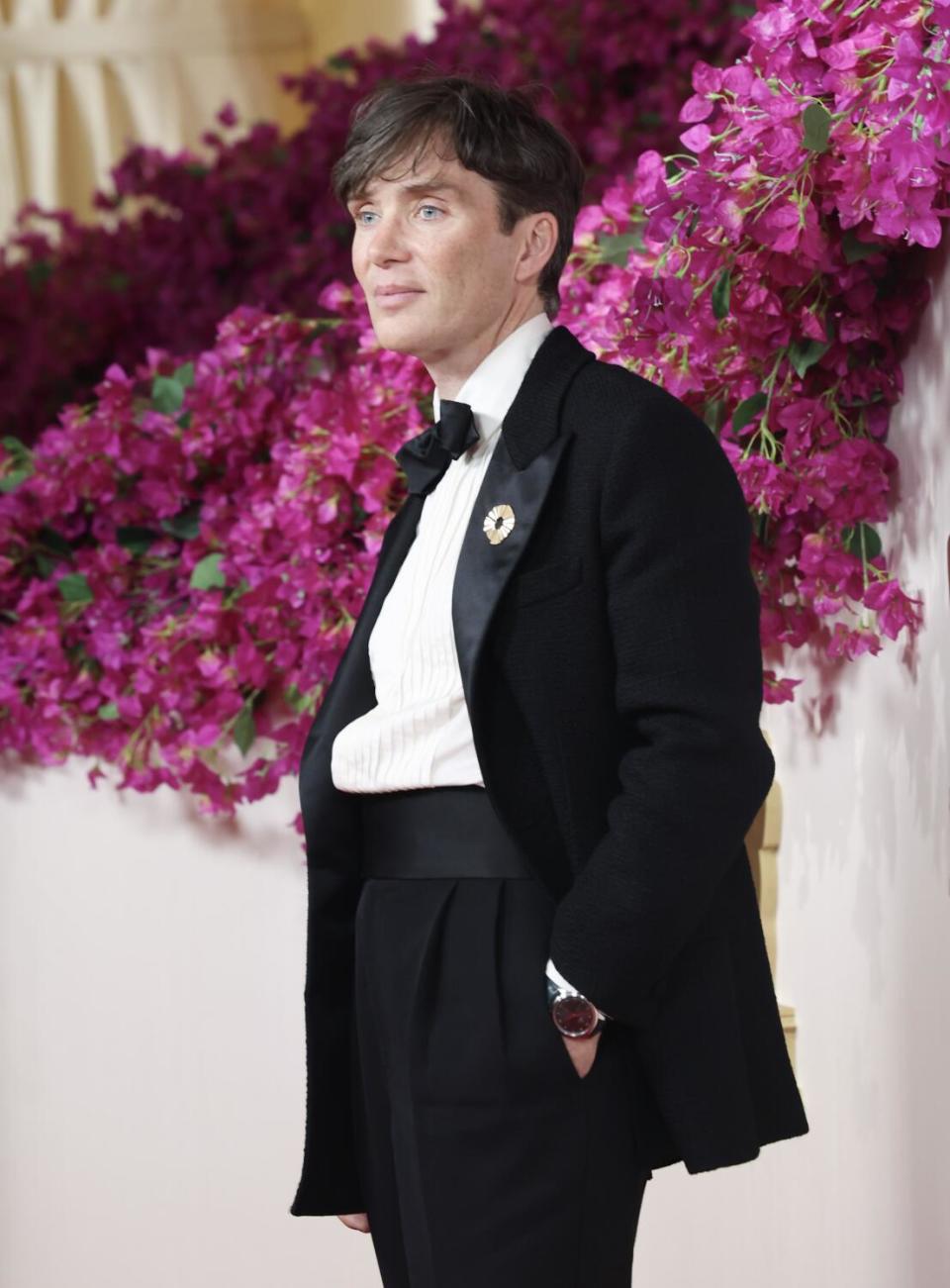 Cillian Murphy wears a black suit, the jacket open.