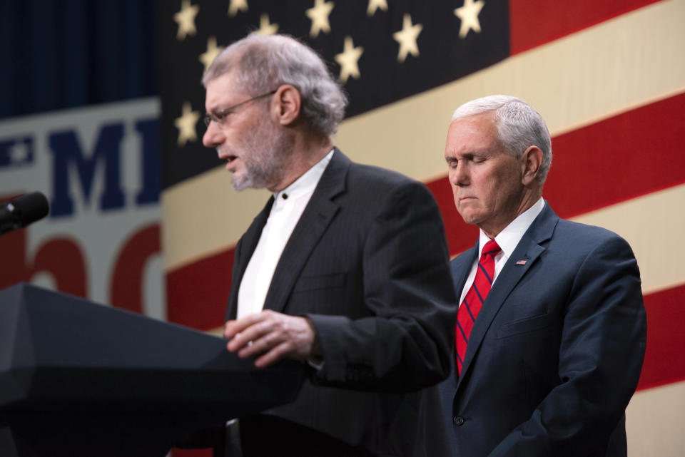 Vice President Mike Pence, right, prays with Rabbi Loren Jacobs, of Bloomfield Hills' Congregation Shema Yisrael, for the victims and families of those killed in the Pittsburgh synagogue shooting, at a rally for Republicans in Oakland County, Monday, Oct. 29, 2018, at the Oakland County Airport in Waterford, Mich. (Tanya Moutzalias/Ann Arbor News-MLive.com via AP)