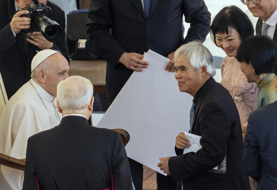 Pulitzer Prize-winning photographer Nick Ut, center, and UNESCO Ambassador Kim Phuc, right, meet with Pope Francis at the end of a general audience in St. Peter's Square at The Vatican, Wednesday, May 11, 2022. Ut and Phuc are in Italy to promote the photo exhibition "From Hell to Hollywood" resuming Ut's 51 years of work at the Associated Press and including Ut's 1973 Pulitzer-winning photo of Kim Phuc fleeing her village that was accidentally hit by napalm bombs dropped by the South Vietnamese air force, (AP Photo/Domenico Stinellis)