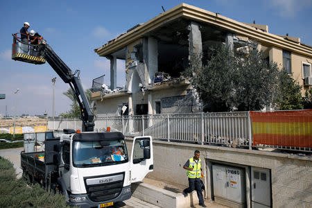 Israeli sappers stand on a crane as they work on a house that the Israeli military said was hit by a rocket fired from the Gaza Strip, in Beersheba, southern Israel October 17, 2018. REUTERS/Amir Cohen