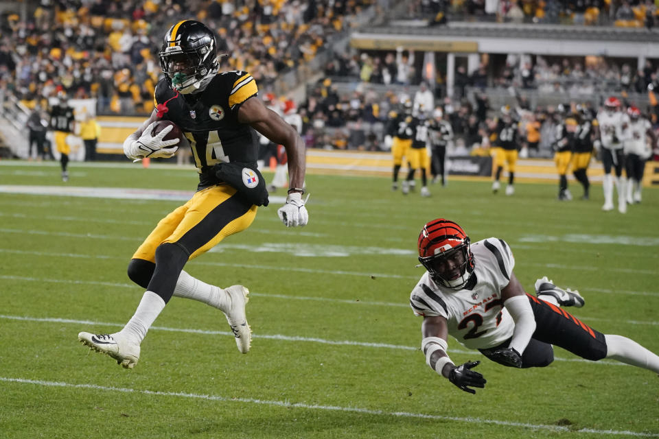 Pittsburgh Steelers wide receiver George Pickens (14) runs past Cincinnati Bengals safety Jordan Battle (27) to run for a 66-yard touchdown during the second half of an NFL football game against the Cincinnati Bengals Saturday, Dec. 23, 2023, in Pittsburgh. (AP Photo/Gene J. Puskar)