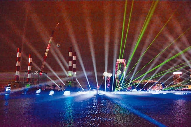 高雄2021跨百光年系列活動24日晚間正式啟動，市府透過雷射光束、無人機將港灣變成大舞台，呈現高雄港光彩奪目的一面。（林宏聰攝）