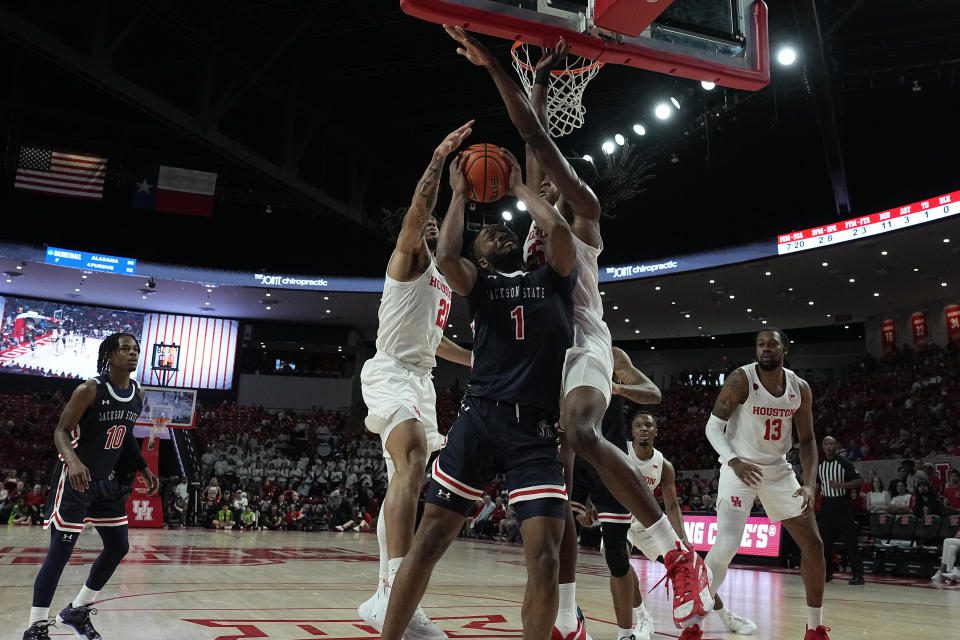 Jackson State forward Zeke Cook (1) is fouled by Houston forward Joseph Tugler (25) during the first half of an NCAA college basketball game, Saturday, Dec. 9, 2023, in Houston. (AP Photo/Kevin M. Cox)