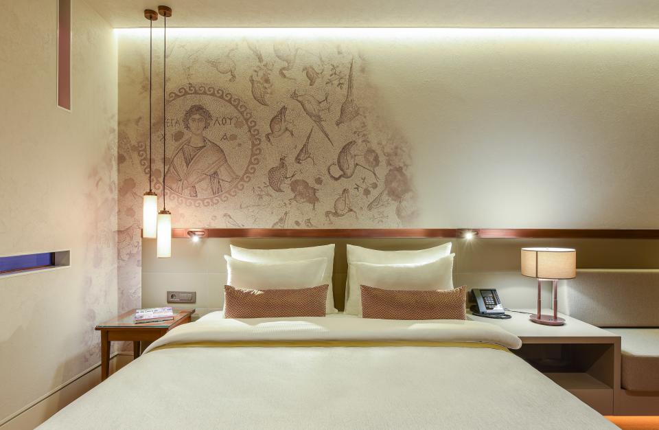 Guest rooms are minimalist with art that reflects the archaeological ruins below.