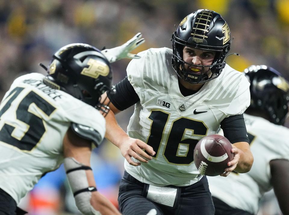 Purdue Boilermakers quarterback Aidan O'Connell (16) hands off the ball to Purdue Boilermakers place kicker Julio Macias (45) on during the Big Ten football championship on Saturday, Dec. 3, 2022 at Lucas Oil Stadium in Indianapolis. Michigan Wolverines defeated the Purdue Boilermakers, 43-22. 